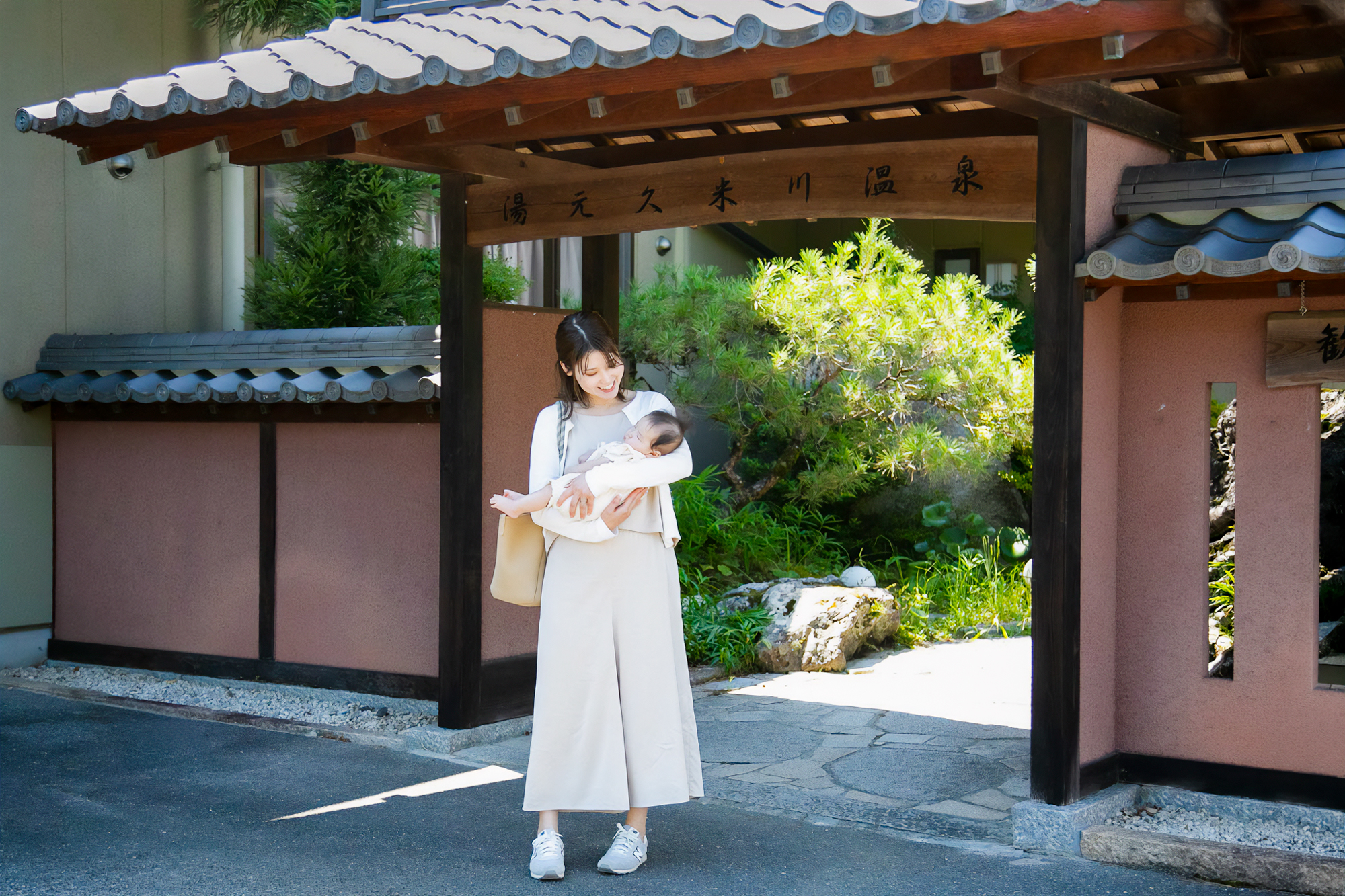 温泉施設の前に立つ母子